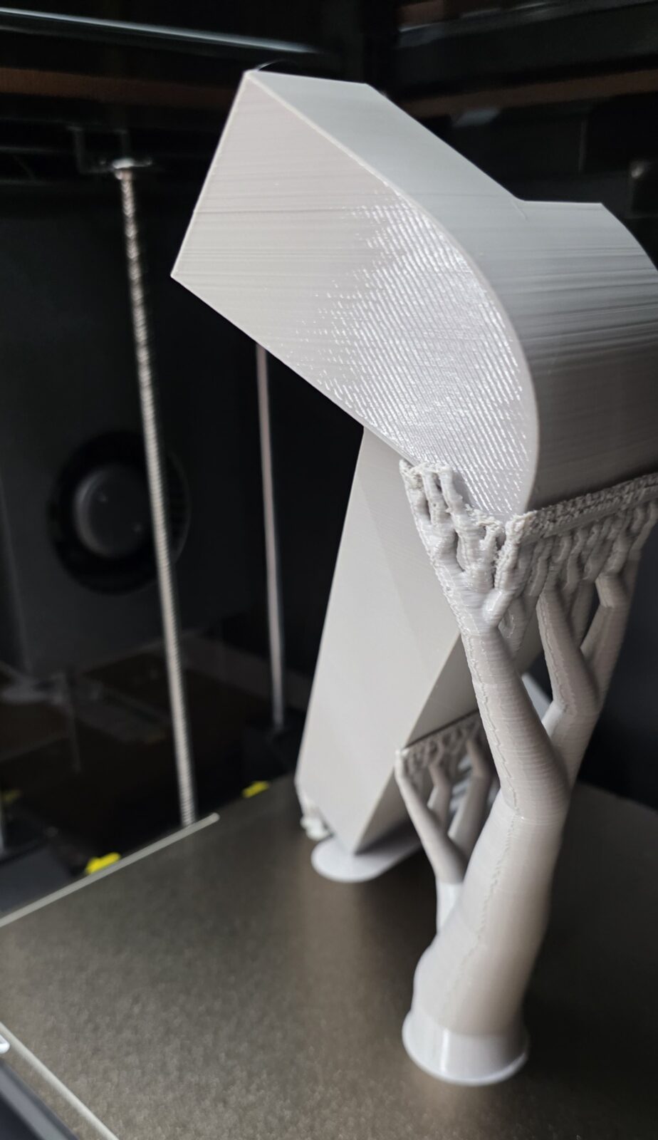 Another angle of the same gray 3D print, with tree supports holding up a large overhang