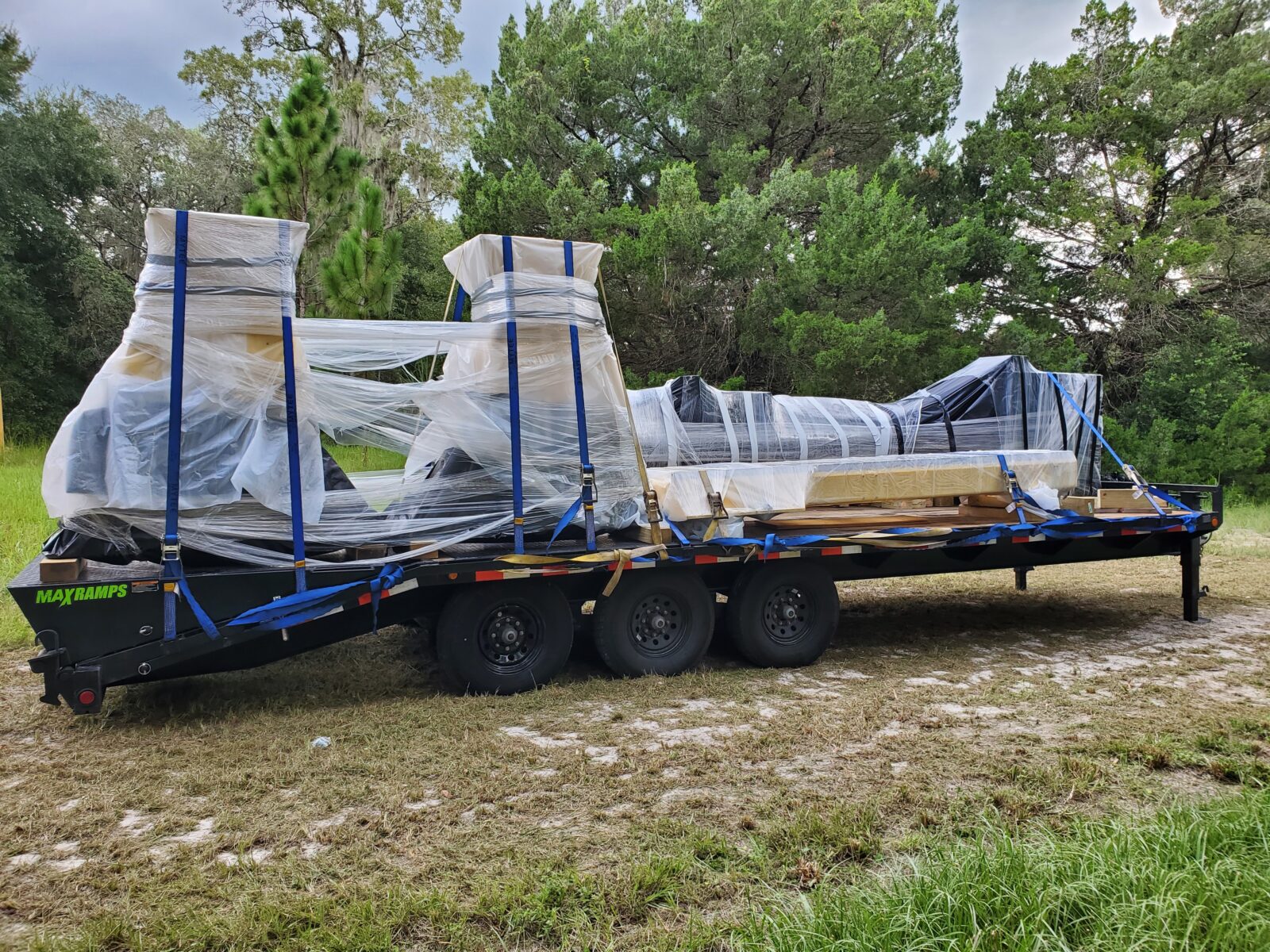The new 5-axis CNC router arriving at the shop, crated and strapped down on a flatbed trailer