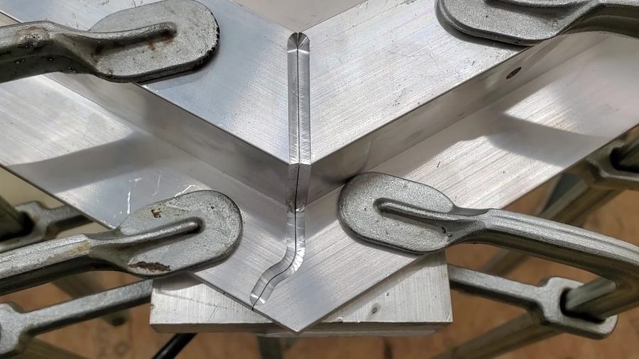 CNC-machined aluminum Z-channel corner clamped for fit-up before welding